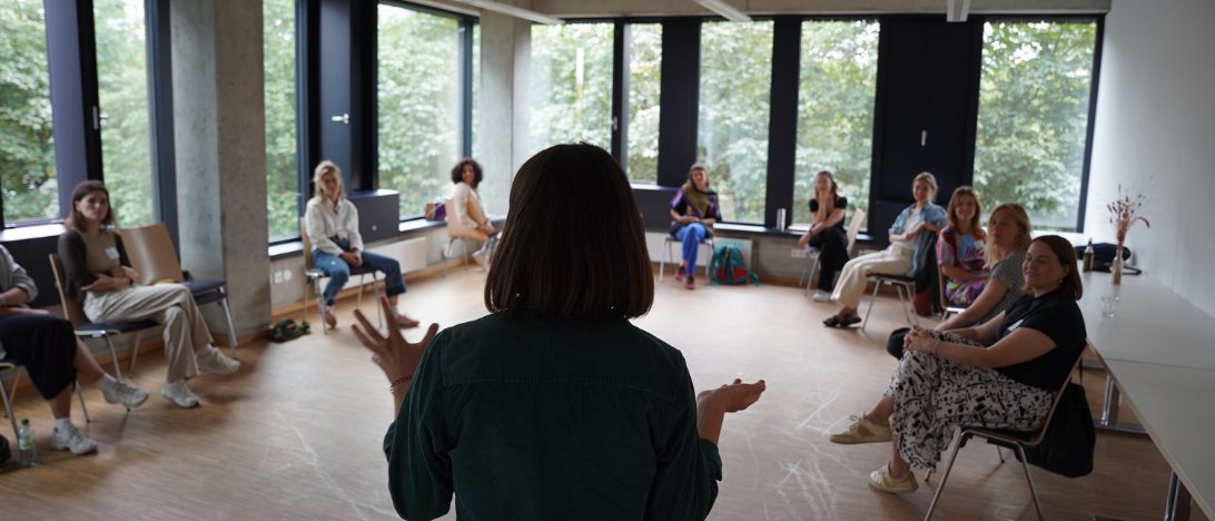Workshop-Situation: eine Marziplan-Beraterin im Gespräch mit einer Gruppe im Stuhlkreis